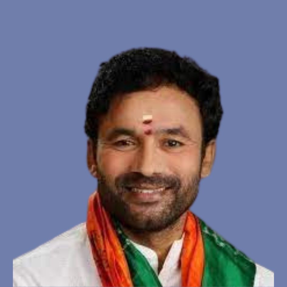 Earlier head-and-shoulders portrait of G. Kishan Reddy smiling, with a saffron and green stole, against a blue background