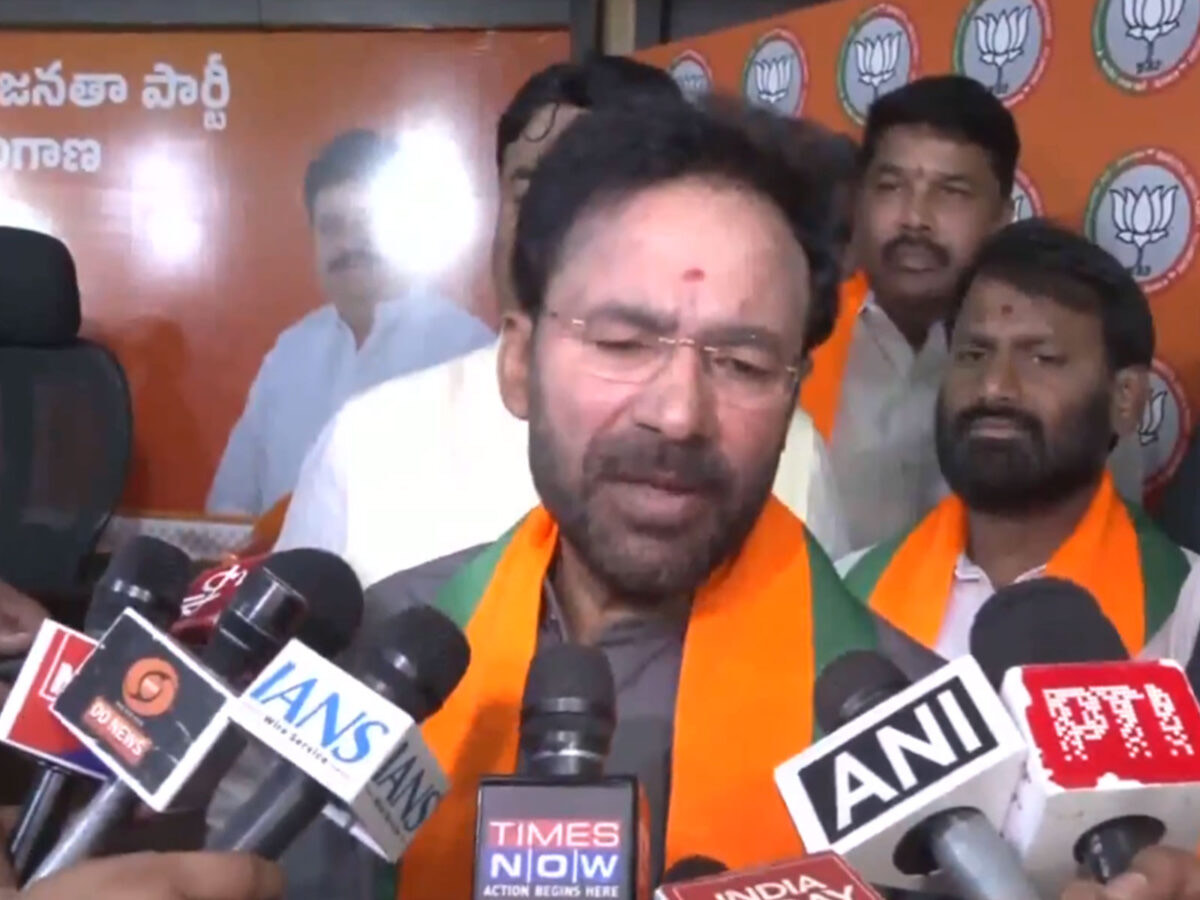 G. Kishan Reddy speaking into a cluster of news microphones including Times Now and ANI, with party colleagues behind him