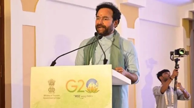 G. Kishan Reddy speaking at a lectern branded with the G20 India logo and the Ministry of Tourism emblem, a camera operator filming to the right